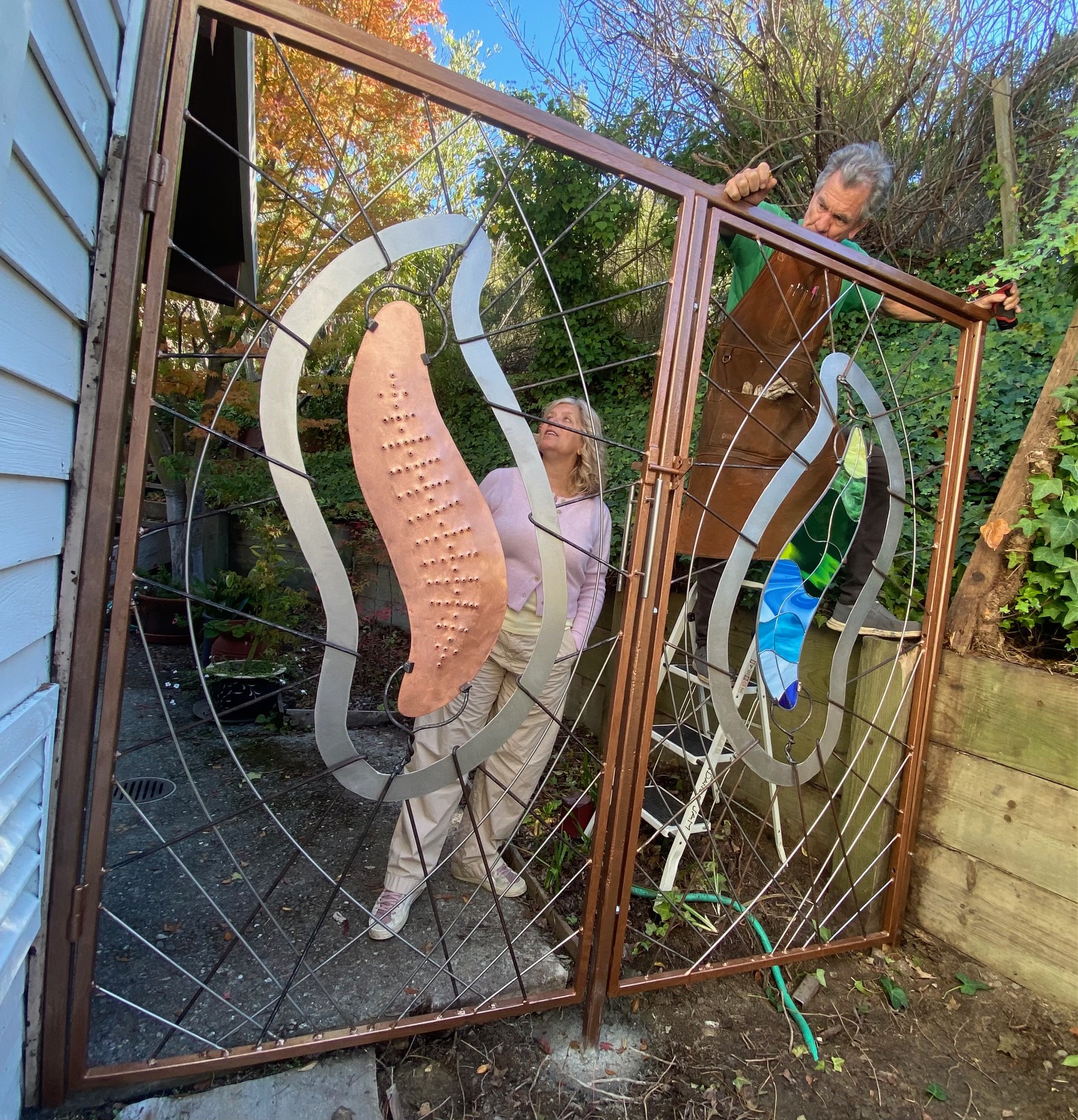 Artisans Andi White and Mark Metz look over the installed gate at the Orinda residence of Betsy Blakeslee. 