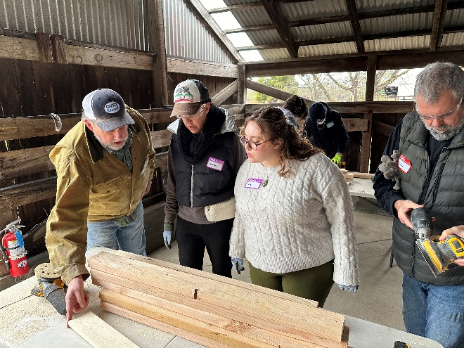 Members learn about bed frame construction as part of a hands-on community service project to provide beds for kids in need.