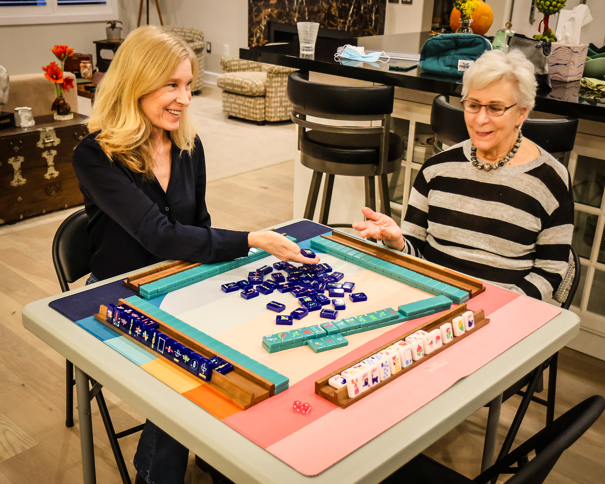 Mah Jongg teacher Alice Stern and her former student, Kara Overaa Gragg, demonstrate with the three new styles of tiles designed by Gragg.