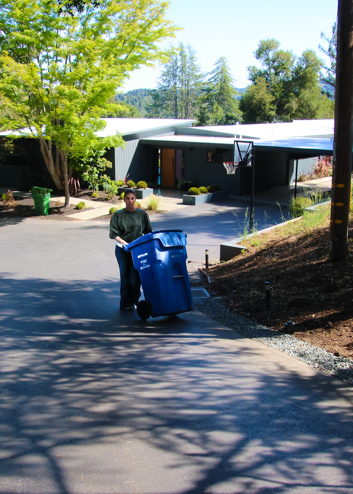 Amber Johnson of Curbside Solutions demonstrates getting a recycling bin up a long, steep driveway.